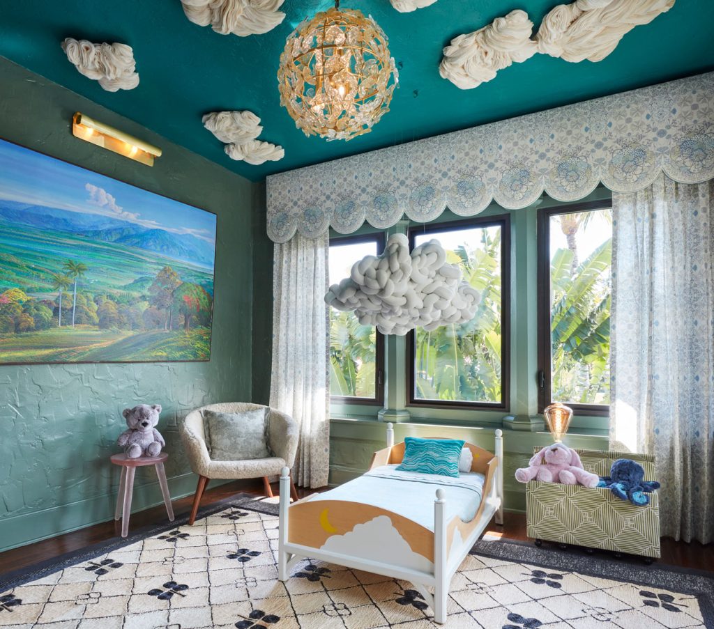 view of teal room with large window and small childs bed and a cloud lamp and large painting