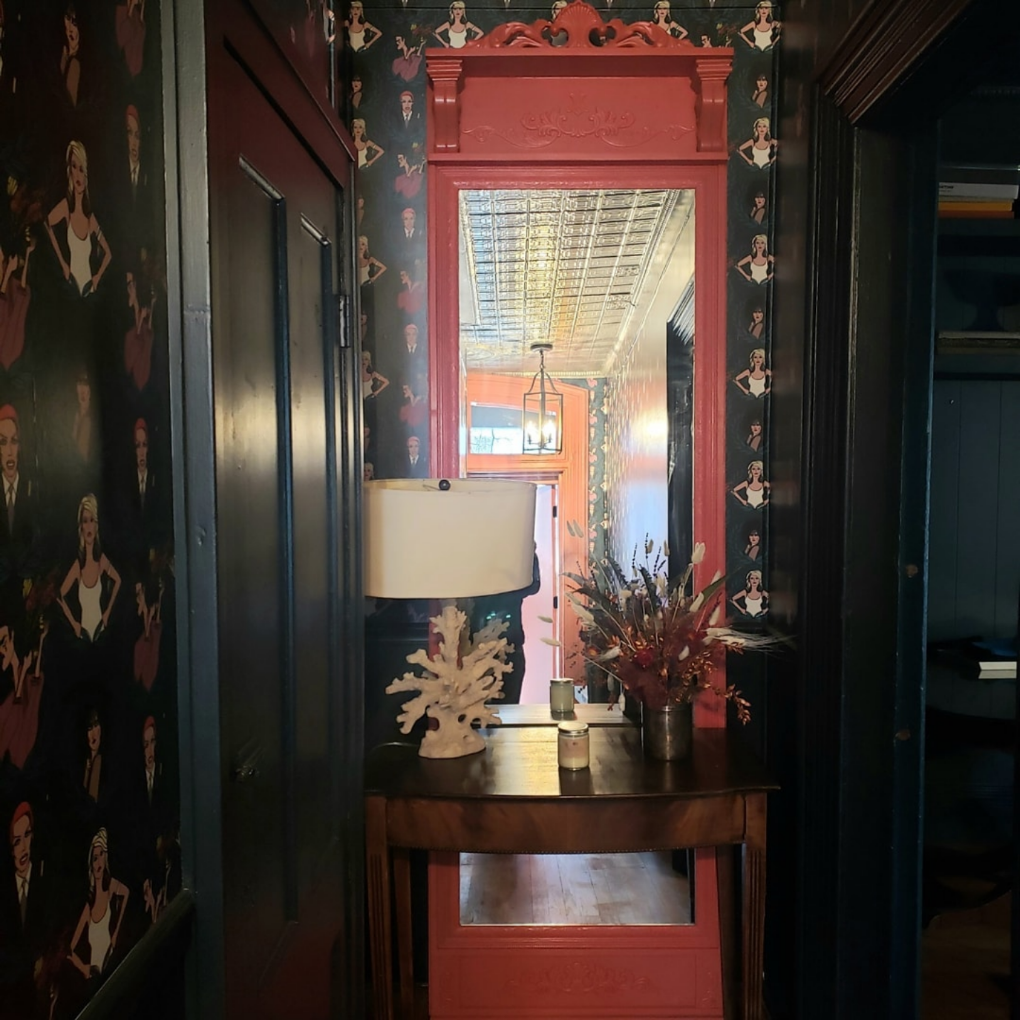 Long wooden frame of ornate mirror in red at the end of a hallway