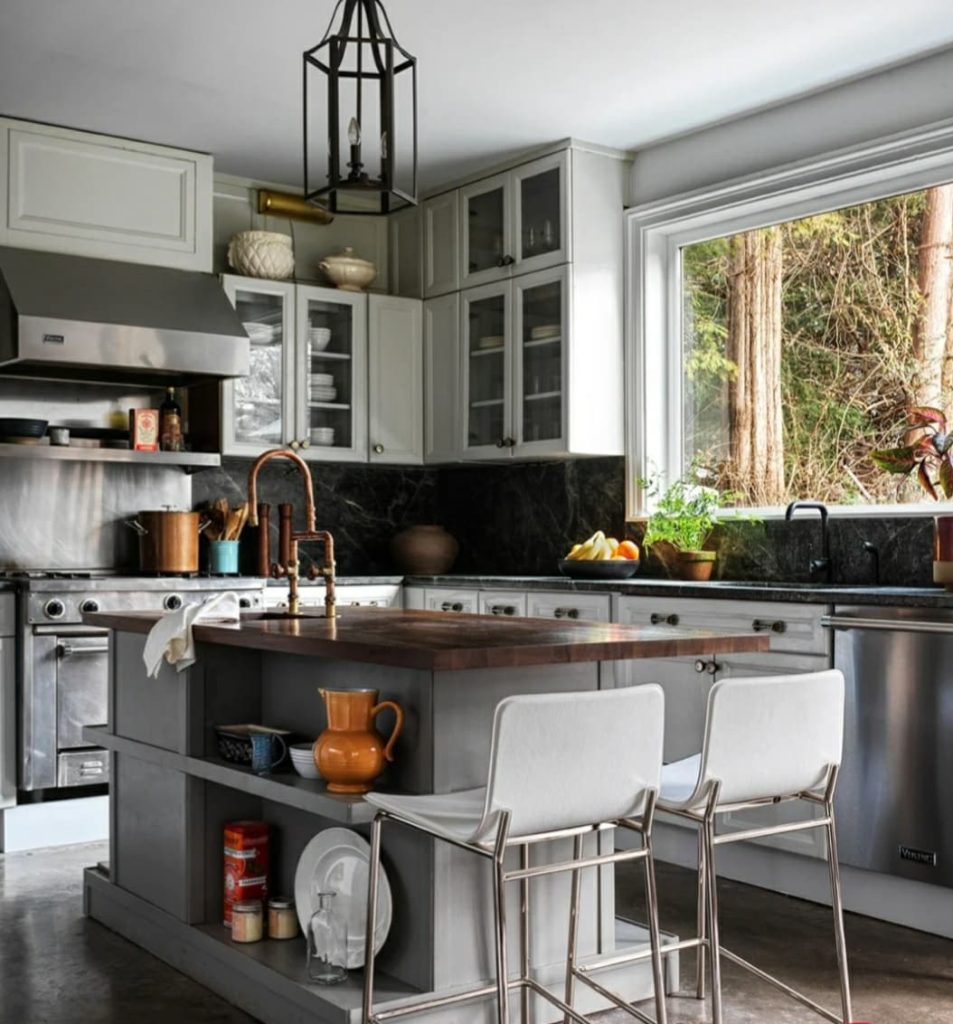 kitchen island with white bar stools in a kitchen with large window