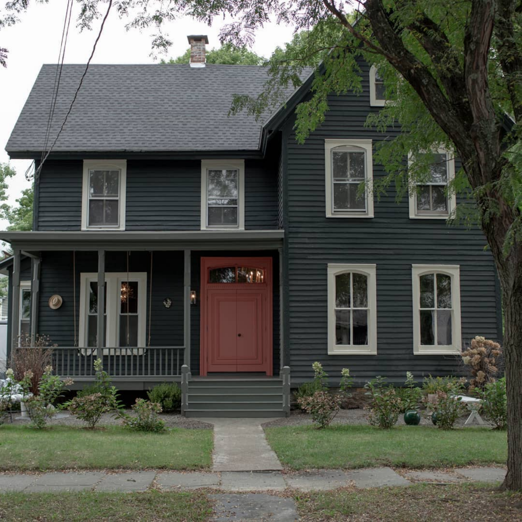 black house with white window accents and red door