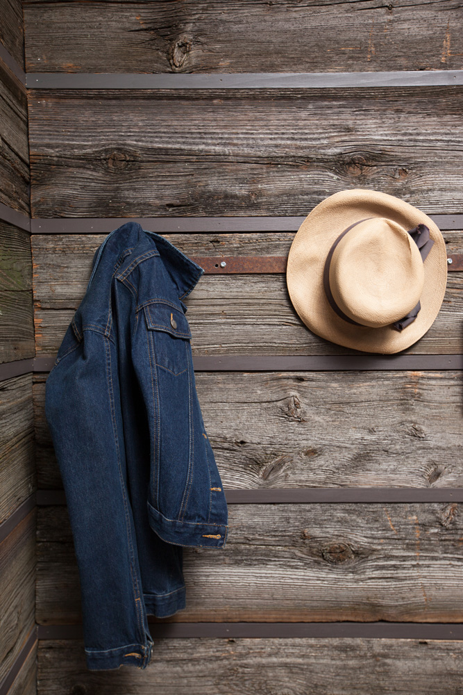 coat and hat hanging on wooden panel walls
